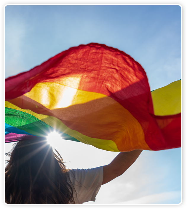 Mulher erguendo a bandeira LGBTQIA+